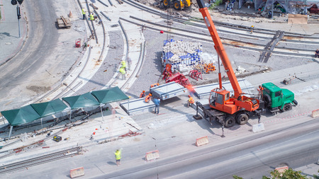 Unloading and installing concrete plates from truck by crane at road construction site timelapse....