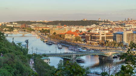 Aerial sunset view of the Vltava River and bridges with traffic evening timelapse, Prague. Boats amd ship floating on water. Warm orange light. Top view from Hanavsky pavilionの写真素材