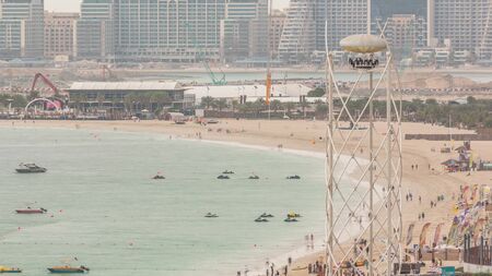 Aerial view of beach and tourists walking and sunbathing on holiday in JBR timelapse in Dubai, UAE. Waterfront with many activities and attractions, shops and restaurantsの写真素材