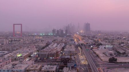 Dubai cityscape during sand storm day to night transition timelapse, aerial view of skyscrapers and traffic on the road from Zabeel district, United Arab Emiratesの写真素材