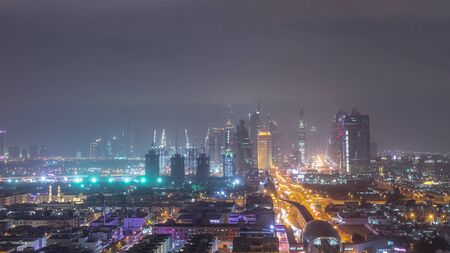 Dubai downtown cityscape during sand storm night timelapse, aerial view of skyscrapers and traffic on the road from Zabeel district, United Arab Emiratesの写真素材