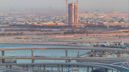 Construction with cranes and intersection near Dubai Creek Harbor aerial timelapse. Dubai - UAE. Top view from Dubai downtown with traffic on a highwayの写真素材