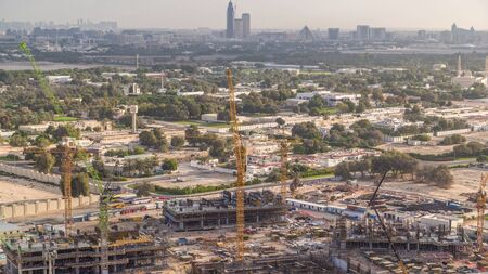 Construction activity in Dubai downtown with cranes and workers aerial timelapse, UAE. Building of new skyscrapers and towers at morningの写真素材