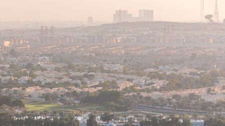 Aerial view to villas and houses with Golf course with green lawn and lakes timelapse. Traffic on streets. Warm evening lightの写真素材