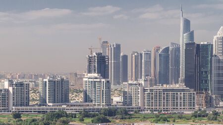 Jumeirah lake towers skyscrapers and golf course morning timelapse, Dubai, United Arab Emirates. Aerial view from Greens district. Green lawn and cloudy skyの写真素材