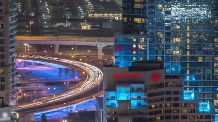 Traffic on the bridge at JBR and Dubai marina aerial night timelapse. Illuminated modern towers and...
