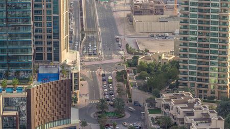 Aerial view of a road intersection in a big city timelapse. Urban landscape of Dubai Marina district...