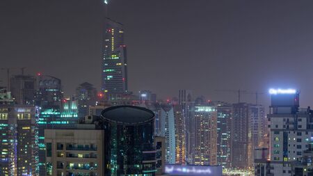 Aerial top view of Dubai Marina and JLT night timelapse. Skyscrapers from above in Dubai, UAE. Illuminated modern towers and traffic on the roadの写真素材