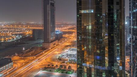 Office buildings in Jumeirah lake towers district night timelapse in Dubai. Aerial panoramic view...