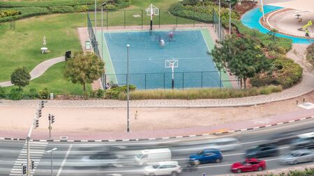 Basketball court at park in Jumeirah Lakes Towers aerial timelapse, a popular residential district...