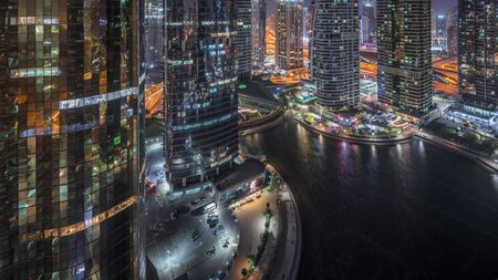 Residential and office buildings in Jumeirah lake towers district night timelapse in Dubai. Aerial panoramic view from above with modern skyscrapersの写真素材