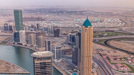 Panoramic aerial view of business bay towers in Dubai at evening timelapse. Rooftop view of some...