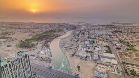 Panorama and aerial view of coastline Dubai at sunset timelapse, United Arab Emirates. Dubai water canal, sheikh zayed road, houses and villas from aboveの写真素材