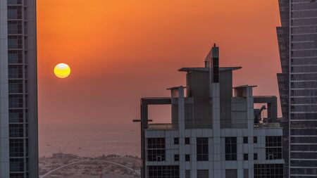 Sunset behind modern residential and office complex aerial timelapse at Business Bay, Dubai, UAE....