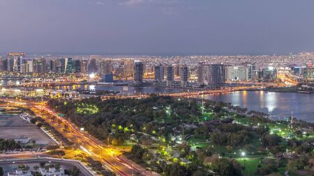 Panoramic view of lights from illuminated roads and windows of skyscrapers day to night transition Timelapse Aerial in Dubai Creek and Deira, United Arab Emiratesの写真素材
