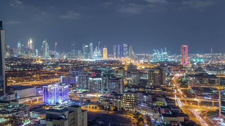 Nighttime Aerial view of lights from new modern buildings at evening with downtown skyscrapers and traffic on roads Timelapse, Dubai, United Arab Emiratesの写真素材