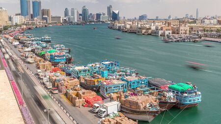 Loading a ship in port timelapse in Dubai, Deira creek, UAE. Aerial top view from above with many...