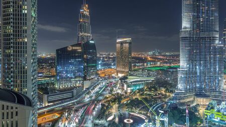 Dubai downtown skyscrapers amazing aerial view at night timelapse with fountains and traffic on streets, Dubai, United Arab Emirates. Illuminated modern towers and construction siteの写真素材