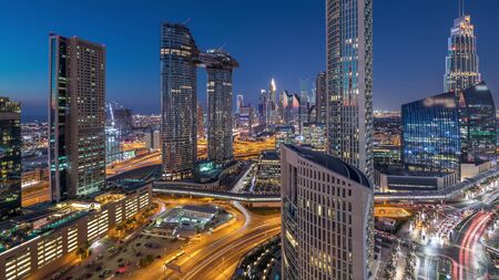 Aerial view of new and tall buildings with busy roads timelapse. Transition from day to night in Dubai Downtown from above, Dubai, United Arab Emiratesの写真素材