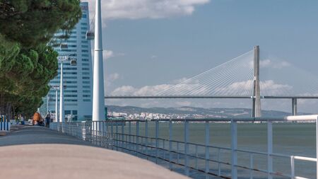 View from river Tagus waterfront of Lisbon's Nations park and Vasco da Gama Bridge timelapse,...