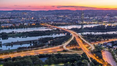 Aerial panoramic view over Vienna city with skyscrapers, highway intersection and a riverside...