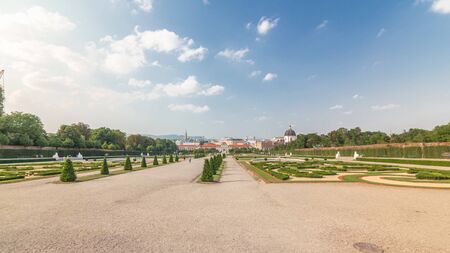 Belvedere palace with beautiful floral garden timelapse hyperlapse, Vienna Austria. Blue sky with clouds on sunny day. Green lawn and historic buildingsのeditorial素材