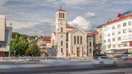 Saint Joseph's Church with city traffic and people on the cross walk on Titova street timelapse hyperlapse in Sarajevo, Bosnia. Cloudy sky at sunny dayの写真素材