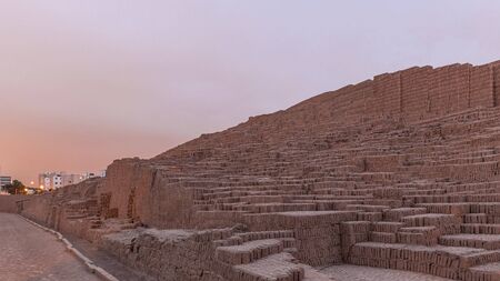 Pyramid of Huaca Pucllana day to night transition timelapse, pre Inca culture ceremonial building ruins in Lima, Peru. Clouds on a sky. Illumination is turning onの写真素材