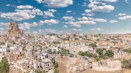 View of Ortahisar town old houses in rock formations from Ortahisar Castle aerial timelapse. Cappadocia. Nevsehir Province. Turkey. Cloudy blue skyの写真素材