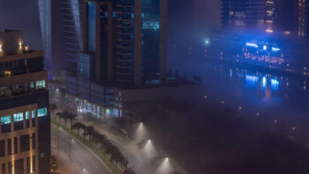 Buildings are covered in thick layer of fog in Business Bay night timelapse.の写真素材