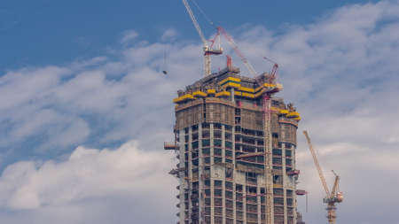 Cranes working on modern constraction site works of new skyscraper timelapse