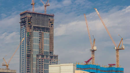 Cranes working on modern constraction site works of new skyscraper timelapseの写真素材