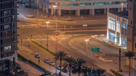 Aerial view of intersection with many transports in traffic and parking night timelapse in Dubai Downtownの写真素材