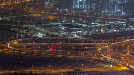 Bussy traffic on the overpass intersection in Dubai downtown aerial night timelapse.
