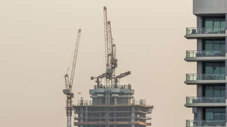 Skyscraper under construction with cranes and iron frame timelapse