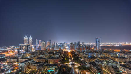 Panorama of skyscrapers in Barsha Heights district and low rise buildings in Greens district aerial night timelapse.の写真素材