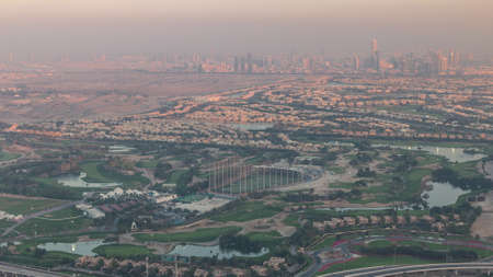 Aerial view to Golf course with green lawn and lakes, villas and houses behind it timelapse.の写真素材