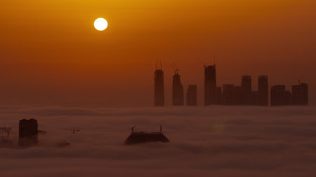 Sunrise over Dubai Creek Harbor with skyscrapers and towers under construction aerial timelapseの写真素材