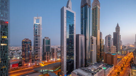 Aerial view of Dubai International Financial District with many skyscrapers night to day timelapse.の写真素材