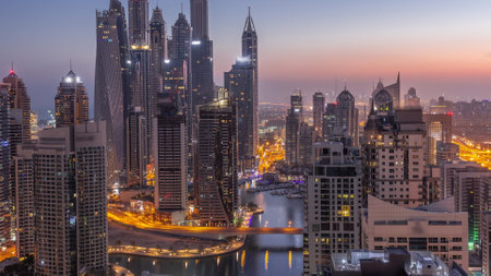 View of various skyscrapers in tallest recidential block in Dubai Marina aerial night to day timelapseの写真素材