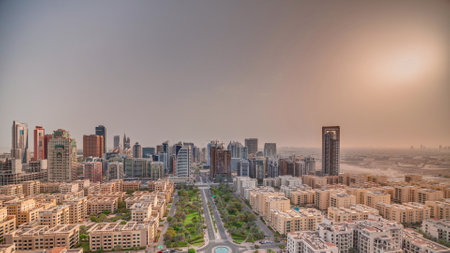 Sunrise over skyscrapers in Barsha Heights district and low rise buildings in Greens district aerial panoramic timelapse. Dubai skyline with orange sky at morningの写真素材
