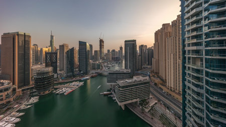 Aerial view to Dubai marina skyscrapers around canal with floating boats all dayの写真素材