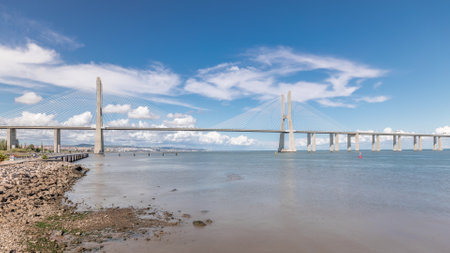 Panorama showing waterfront and the Vasco da Gama Bridge timelapse. Cable-stayed longest bridge flanked by viaducts and range views that spans the Tagus River in Park of Nations in Lisbon, Portugalの写真素材