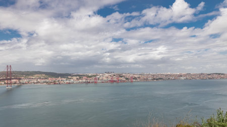 Panorama showing Lisbon cityscape and Tagus river timelapse with 25 of April bridgeの写真素材