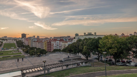 Panorama showing sunset over lawn at Alameda Dom Afonso Henriques and the aerial timelapse in Lisbon.の写真素材