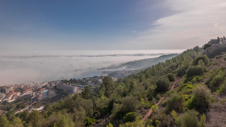 Panorama showing aerial View of Sesimbra Town and Port covered by fog timelapse, Portugal.の写真素材