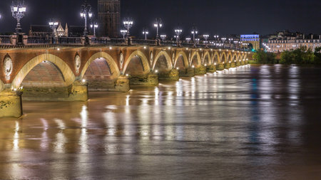 Pont de Pierre stone bridge with Porte de Bourgogne night timelapse in Bordeaux, France.の写真素材