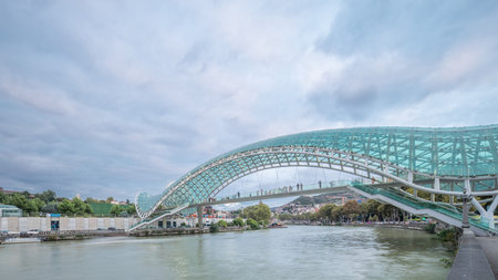 Timelapse panorama of the Bridge of Peace, a bow-shaped pedestrian bridge in Tbilisi, Georgiaの写真素材