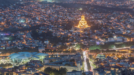 Illuminated Tsminda Sameba Cathedral or Holy Trinity Cathedral of Tbilisi and Public Service Hall...