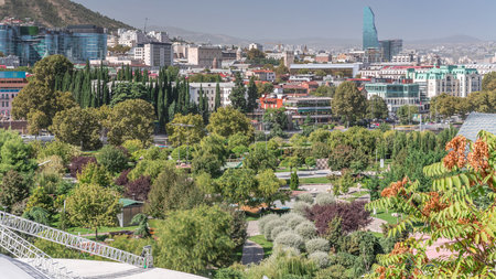 Aerial timelapse of Rike Park, a modern urban park in Tbilisis Old Town with green trees and lawns. The Bridge of Peace in the background. Georgiaの写真素材